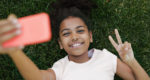 Smiling girl taking selfie on her smartphone