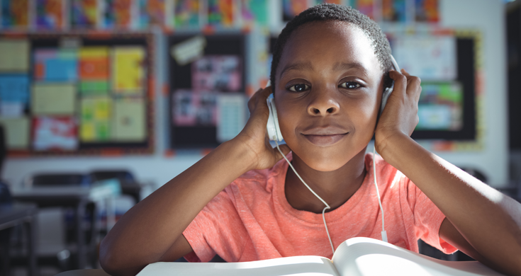 child wearing headphones while studying in class