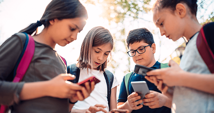 group of kids using cell phones for social media