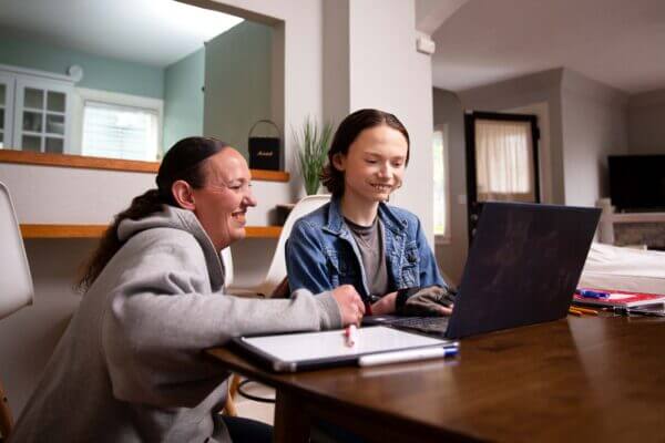 Adult and student at laptop on table