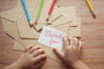 Child holding thank you card
