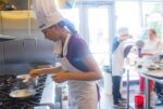 Student at stove in a chef's hat