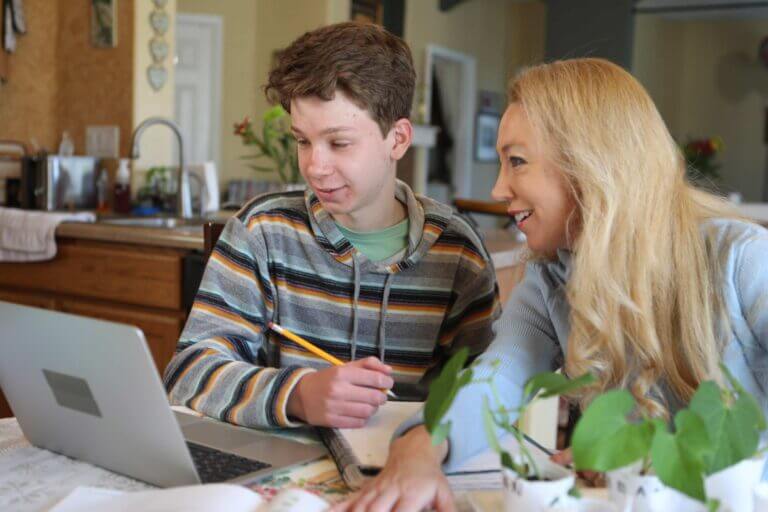 Student and adult at a laptop