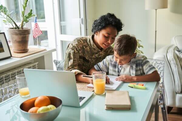 Soldire with student at laptop