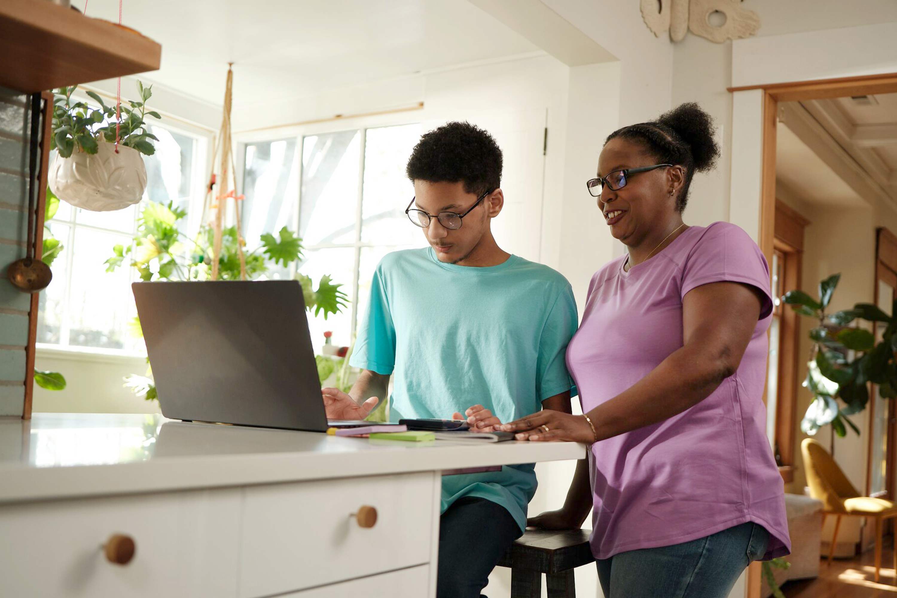 Mother and son working together with their laptop