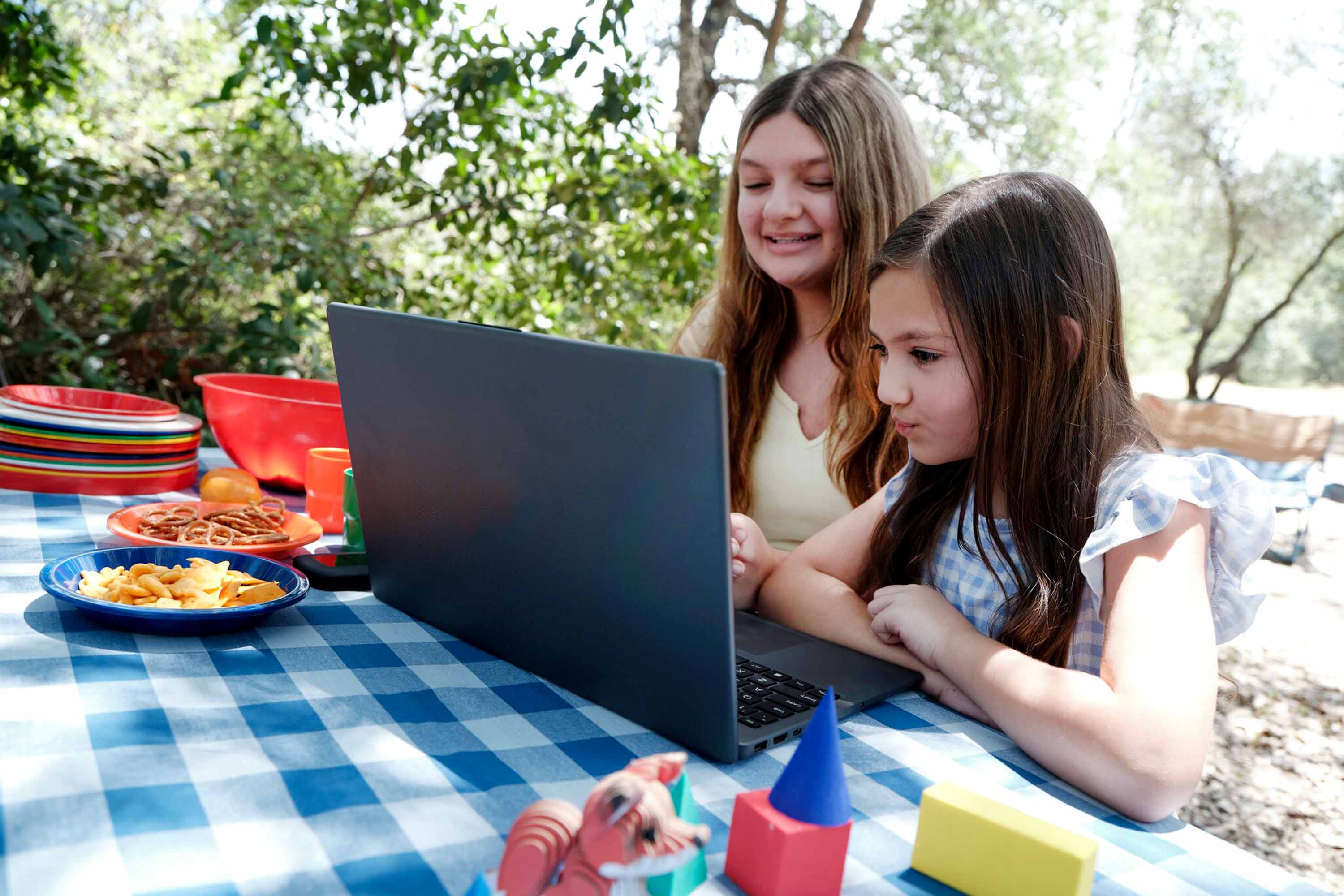 Mother and her daughter working together with their laptop
